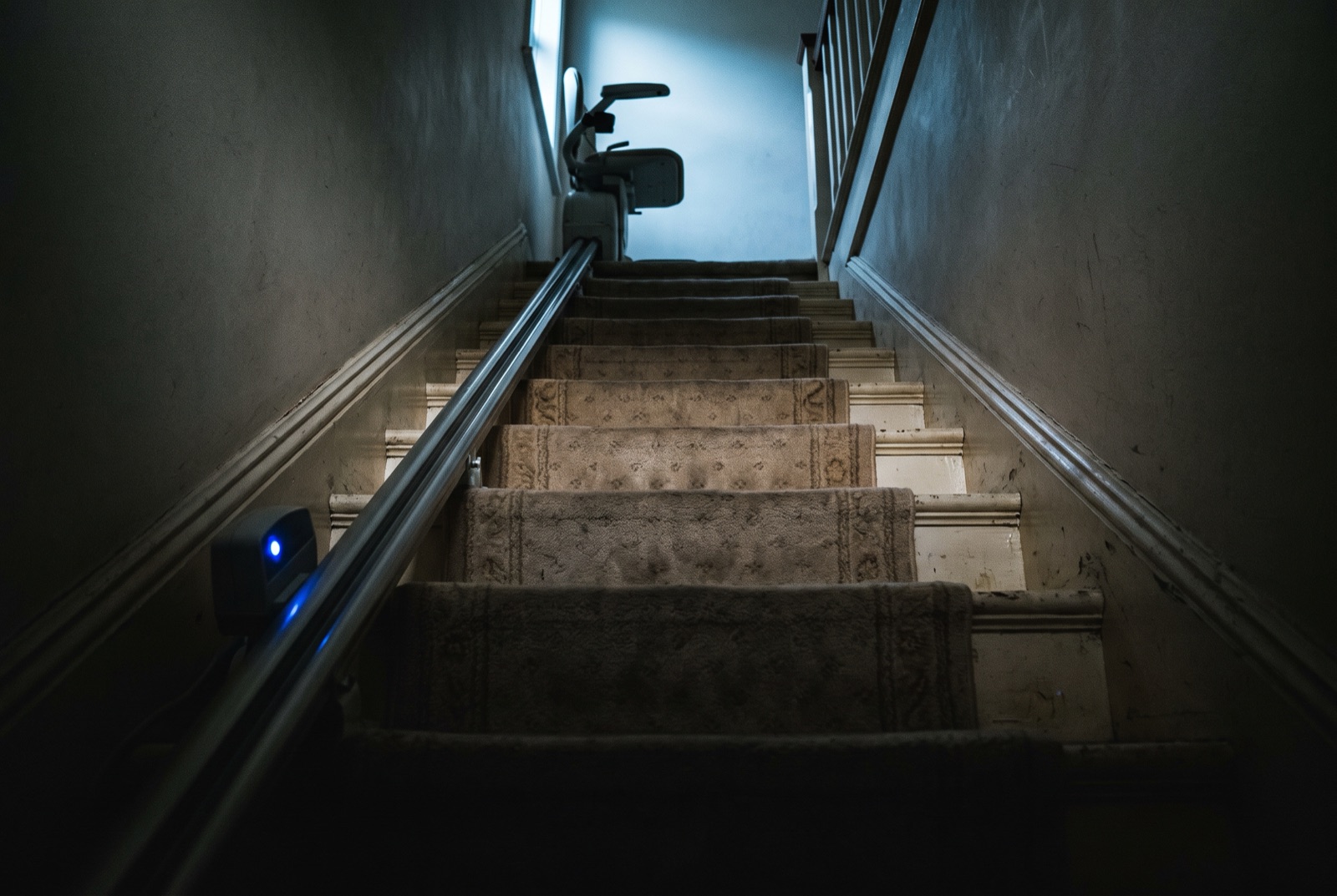 A domestic staircase with a stairlift rail newly fitted along it